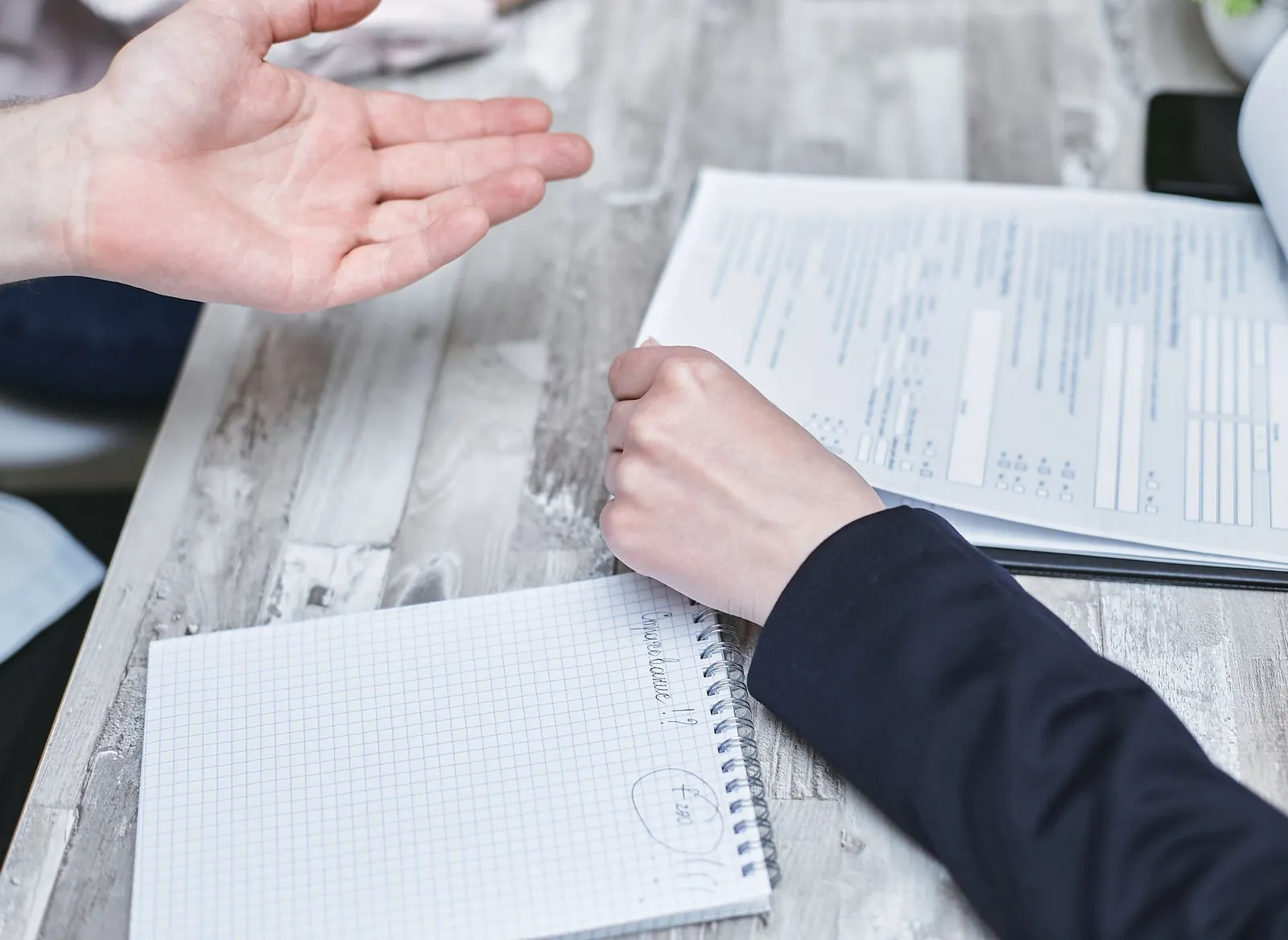 Two people reviewing documents across a desk