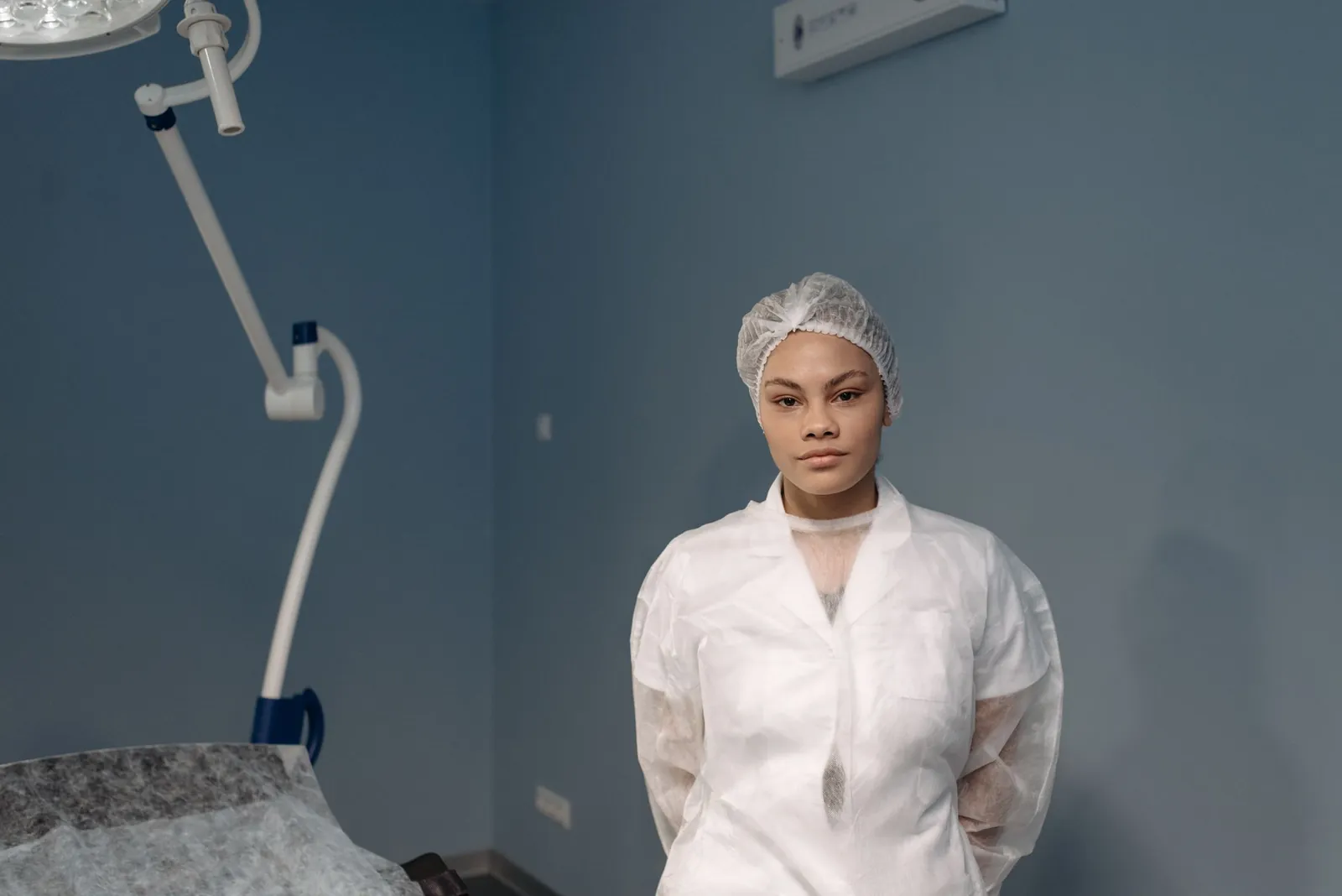 A medical professional in a white gown standing in a clinic room